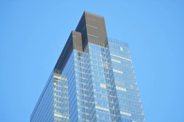 Berrak Mavi Gökyüzüne Karşı Geometrik Görünüm Tasarımı ile Modern Cam Gökdelen