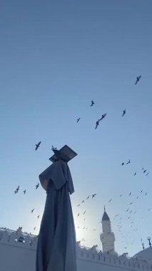 Madina 'daki Quba Camii' nin üzerinde uçan güvercin sürüsü