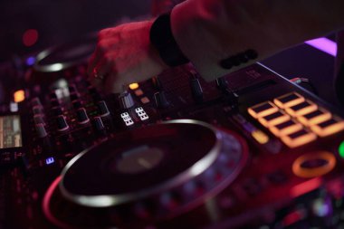 DJ hand adjusting an audio controller during a performance, highlighting technology, creativity and the vibe of electronic music. Ideal for event, sound and entertainment themes. clipart