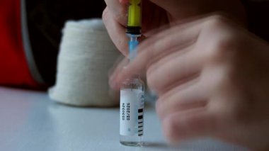 Şırıngayı şişeye koy. İki milimetre. Yakın çekim.