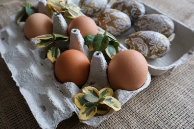 Süslü yapraklı bir tepside paskalya ve normal yumurta..