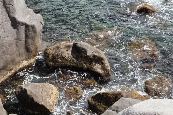 Deniz dalgaları taşlara çarptı..