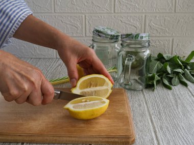 Kadın içki yapmak için limonu boydan boya kesti..