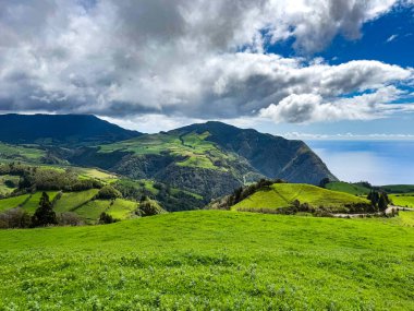 Turkuaz su, yeşil yamaçlar ve Azores 'teki açık gökyüzü ile Lagoa do Fogo' nun göz kamaştırıcı panoramik görüntüsü.