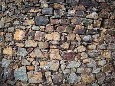 Değişik kaya boyutları ve sıcak tonlarını gösteren kaotik taş yerleştirme manzarası