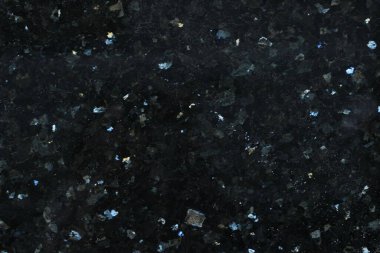 Pürüzsüz bir yüzeyi ve parlak ve beyaz benekleri olan koyu renkli fayansların yakın çekim dokusu