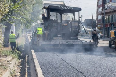 Bishkek, Kyrgyzstan - September 15, 2024: Laying new asphalt on the streets of Bishkek. clipart