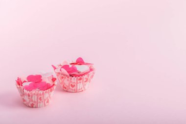 Pembe arka planda dekoratif kalpleri olan kağıt kek kutuları. Sevgililer günü, doğum günü, anneler günü konsepti.