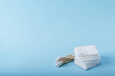 Bambu eko pamuklu bezler ve pamuklu pedler mavi arka planda kişisel hijyen için. Boşluğu kopyala.