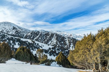 Karlı dağların üzerindeki bulutlu gökyüzü.