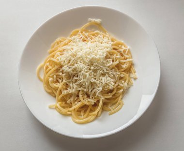 Beyaz tabakta peynirli makarna. Hızlı Tarifler.