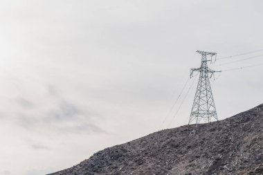 Kırgızistan 'ın dağlık bölgelerindeki yüksek voltajlı elektrik hatlarını destekleyen elektrik kuleleri. Dağlarda ulaşılması zor bir yerde güç aktarım hattı, inşaat teknolojileri.