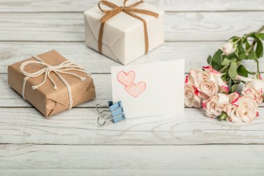 Güller, kalplerin kalem çizimleri ve tahta arka planda hediye kutuları. Anneler Günü 'nü, Sevgililer Günü' nü, Doğum Günü 'nü ve Kadınlar Günü' nü kendin kutla..