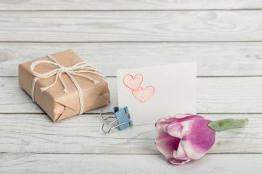 Lale, kalplerin kalem çizimi ve tahta bir arka planda hediye kutusu. Anneler Günü 'nü, Sevgililer Günü' nü, Doğum Günü 'nü ve Kadınlar Günü' nü kendin kutla..