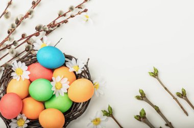 Bayramlık Paskalya arkaplanı. Renkli yumurtalar, söğüt dalları ve yeşil tomurcuklar.