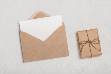 Davetiye ya da tebrik kartı maketi, el işi zarf ve arka planda el işi hediye kutusu. Minimalist tebrik..