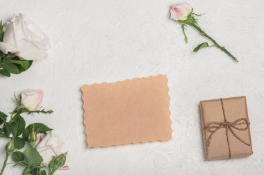 Boş el işi hediye kutusu, beyaz şakayık çiçekleri ve arka planda okaliptüs tomurcukları olan tebrik kartı modeli...