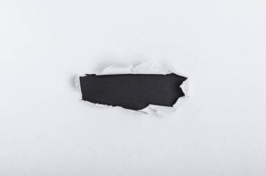 Reklam içeriğiniz veya promosyonunuz için ortası delik olan yırtık beyaz bir arkaplan. Bir nesne eklemek için boş alan. İlerleme kavramı. Kağıt yoluyla