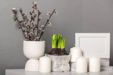 Bahar aylarında sümbüllü saksılar, mumlar, söğüt dallı vazolar. İskandinav iç mimarisi.