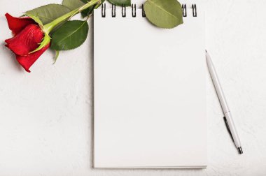 Tebrik kartı. Bir kalem ve kırmızı bir gül ile defteri aç.