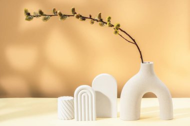 Alçı figürler ve söğüt dallı modern bir seramik vazo. Bahar ışıl ışıl.