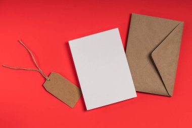 Tebrik kartı, davetiye modeli. Kraft zarfı ve kırmızı arkaplanda boş kart.