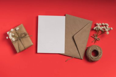 İçinde boş kart, çingene ve kırmızı arka planda hediye kutusu olan bir zarf. Tebrik kartı, davet modeli.