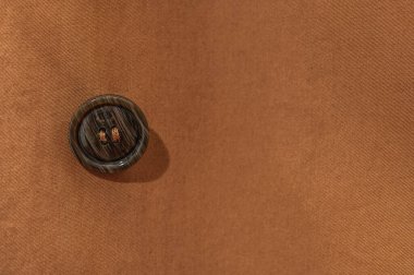 Terracotta yağmurluğundaki bir düğme. Düğmeli tekstil arkaplanı.