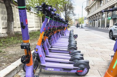 Moskova, Rusya - 22 Nisan 2024: Sokakta bir dizi mor elektrikli scooter. Moskova 'da elektrikli scooter kiralarız..