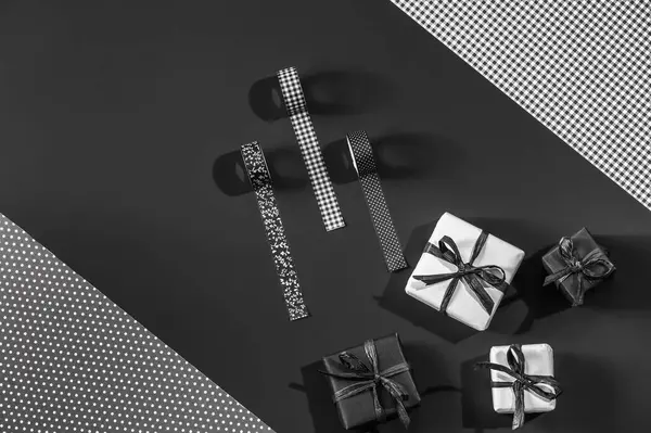 Siyah ve beyaz hediye kutuları ve siyah dekoratif kasetlerle siyah ambalaj kağıtlarında metin için yer var.
