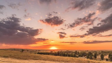 Parlak, sıcak yaz günbatımı tepelerin ardında.
