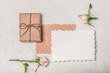 Tebrik kartı modeli, içi boş, el işi hediye kutusu ve arka planda iki gül.