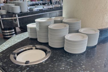 Otel büfesinde bir yığın beyaz tabak..