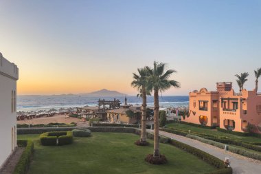 Sharm El Sheikh, Mısır - 7 Mayıs 2025 Charmillion Hotel plajı ve Tiran Adası manzarası. Rahatlamış yaz tatili ve seyahat konsepti.