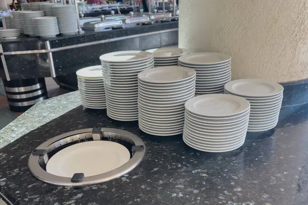 Otel büfesinde bir yığın beyaz tabak..