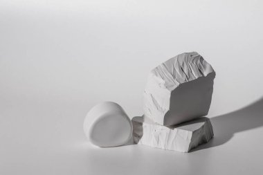 Hafif arkaplan üzerinde alçı beyaz taşlar podyumu. Minimum boş ürün tanıtım aşaması.