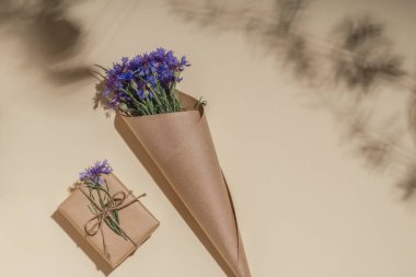 Çiçek buketi ve el işi kağıdında hediye kutusu. Tebrik kartı modeli.