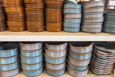 Bir rafta seramik kaseler yığını.