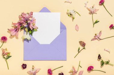 Pembe çiçekli leylak zarf ve bej arka planda boş antetli antetli. Kartpostal düzeni.