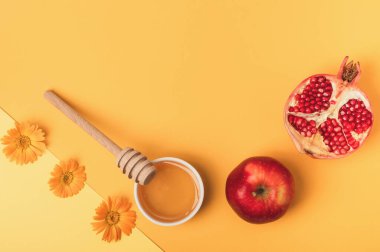 Bal, elma, yarım nar ve sarı arka planda çiçekler. Tatil (Rosh Hashanah). Yahudi Yeni Yılı. Düz bileşim.