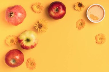 Bal, elma, nar ve sarı arka planda çiçekler. Tatil (Rosh Hashanah). Yahudi Yeni Yılı. Düz bileşim.