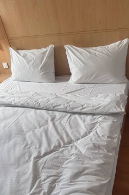 Otelde yeni yapılmış bir yatakta iki yastık ve bir battaniye. Rahat konaklama.