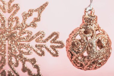 Noel arkaplanı, Noel kartı. Pembe arka planda Noel ağacı oyuncakları ve çelenkler. Seçici odak.