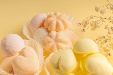 Narin marşmelovlu beyaz turtalar ve kremalı sarı arka planda bir tutam çigila. Tebrik kartı, davet.