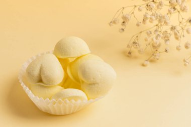 Sarı marşmelovlu beyaz turtalar ve narin sarı arka planda bir tutam çigila. Tebrik kartı, davet.