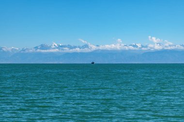 Kırgızistan 'daki Issyk-Kul Gölü' nün panoramik manzarası. Ufukta küçük bir gemi var..
