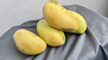 Gri masadaki sarı mango