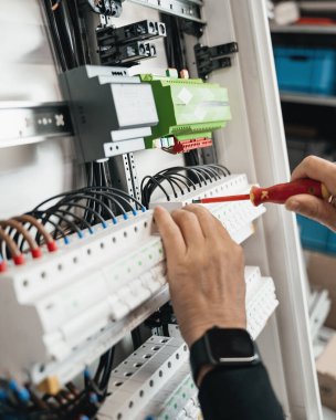 Akıllı bir ev elektrik kutusuna bağlanmış bir kabloya yakın çekim. Görüntü, gelişmiş ev otomasyon teknolojisini yansıtan ve kutunun içinde düzenli olarak düzenlenmiş karmaşık kablo detaylarını sergiliyor.