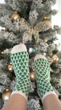 Süslü bir Noel ağacının arka planında yeşil Noel ağaçları olan çoraplı kadınlar. Yüksek kalite 4k görüntü