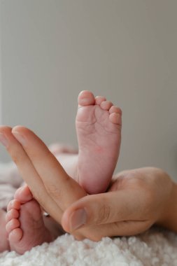 Yeni doğmuş bir bebeğin ayakları annenin ellerinde, yakın plan. Yüksek kalite fotoğraf